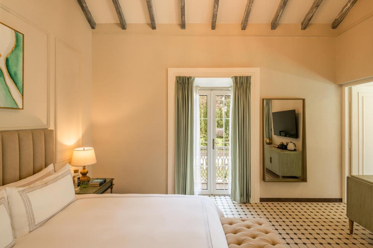 a bedroom with a bed and a mirror at MansionHaus in Anjuna