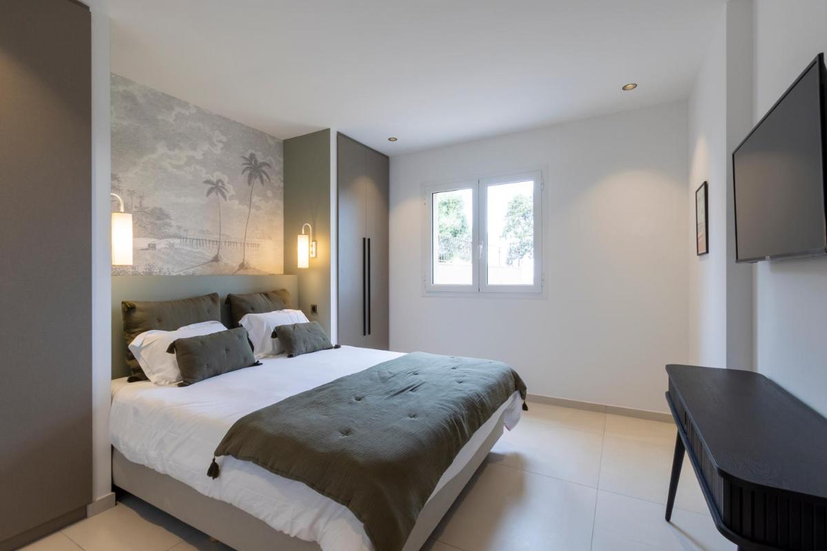 une chambre avec un grand lit et une table dans l'établissement Résidence Omigna, à Cargèse