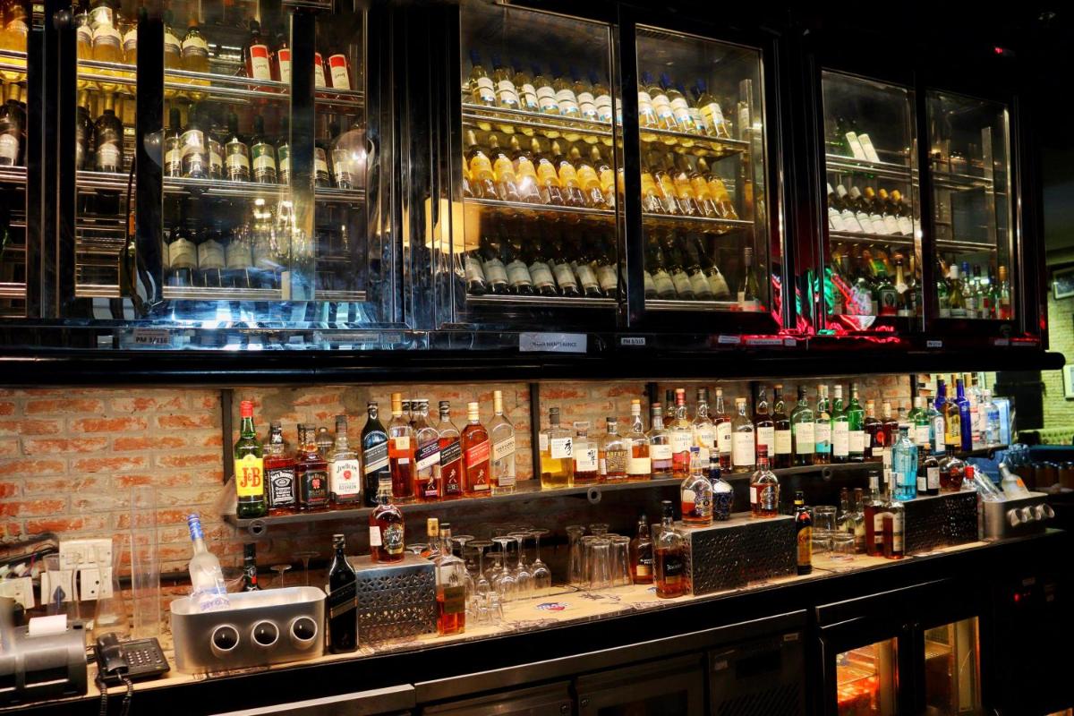 a bar with a lot of bottles of alcohol at Holiday Inn Jaipur City Centre by IHG in Jaipur a bar with a lot of bottles of alcohol at Holiday Inn Jaipur City Centre by IHG in Jaipur