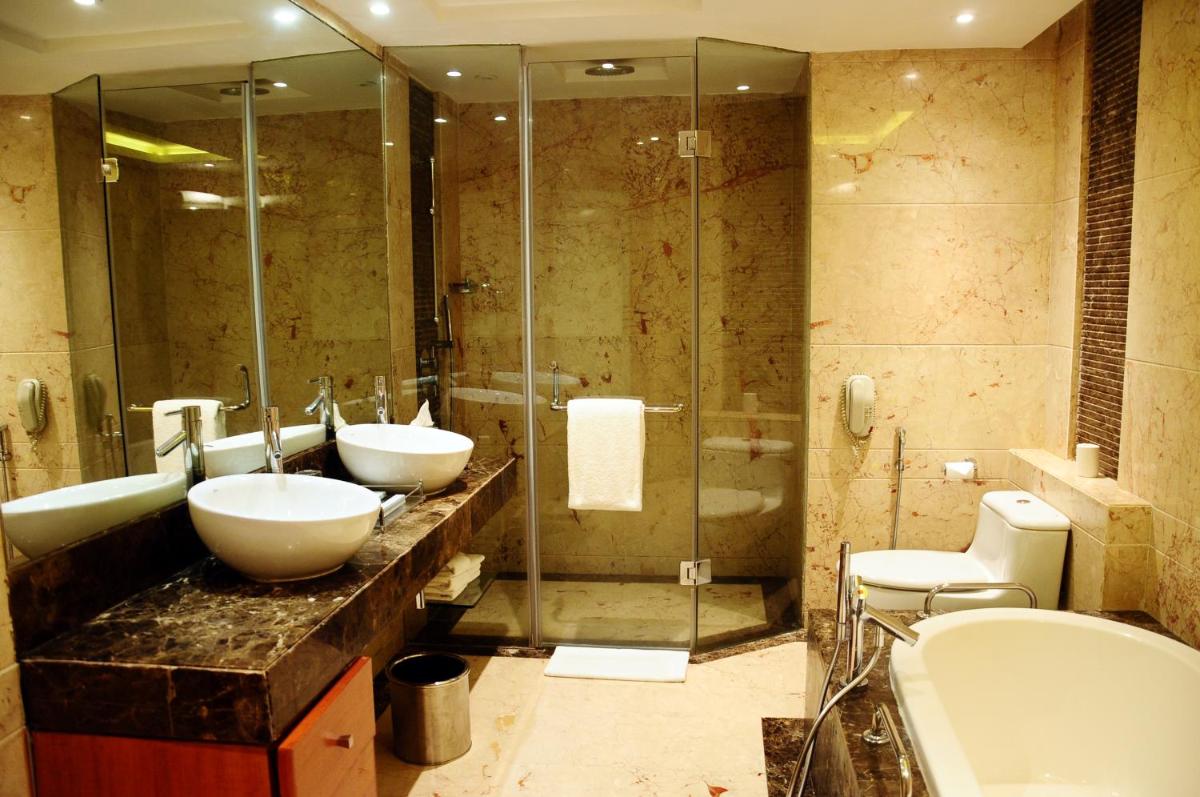 a bathroom with two sinks and a shower at Radisson Blu Plaza Delhi Airport in New Delhi a bathroom with two sinks and a shower at Radisson Blu Plaza Delhi Airport in New Delhi