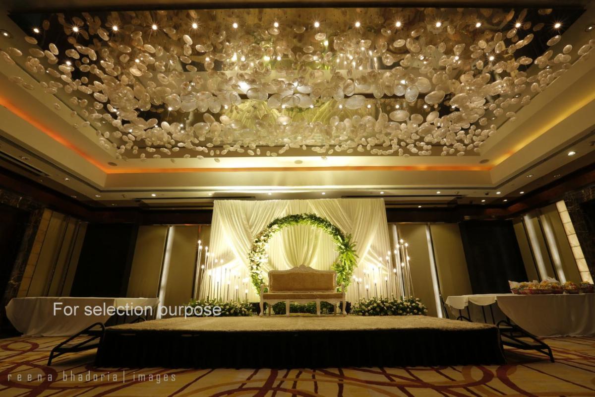a banquet hall with a stage and a chandelier at Radisson Blu Plaza Delhi Airport in New Delhi a banquet hall with a stage and a chandelier at Radisson Blu Plaza Delhi Airport in New Delhi