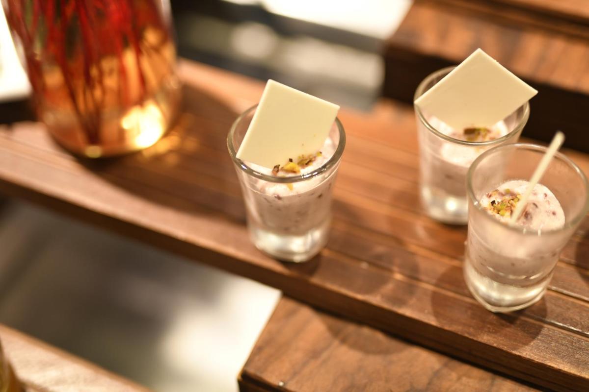 a wooden table with three glasses of dessert on it at Radisson Blu Plaza Delhi Airport in New Delhi a wooden table with three glasses of dessert on it at Radisson Blu Plaza Delhi Airport in New Delhi