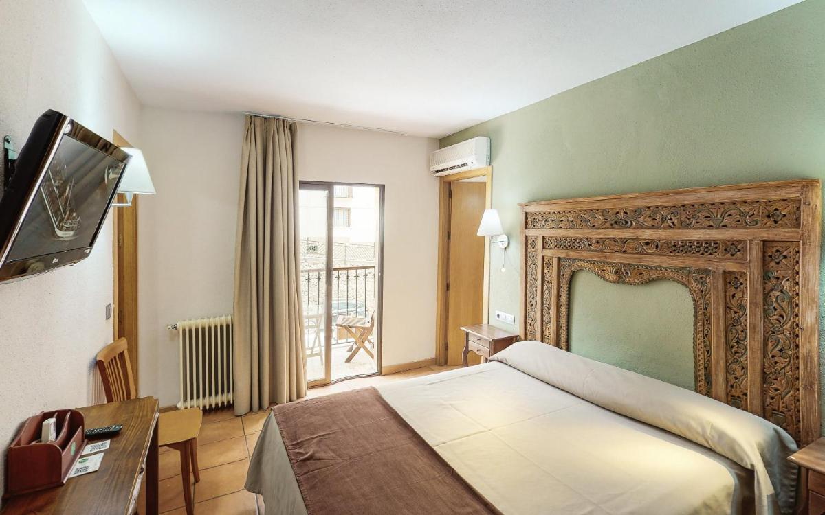 Una habitación de hotel con una cama y una ventana. en Hotel Sierra de Cazorla & SPA 3*, en Cazorla