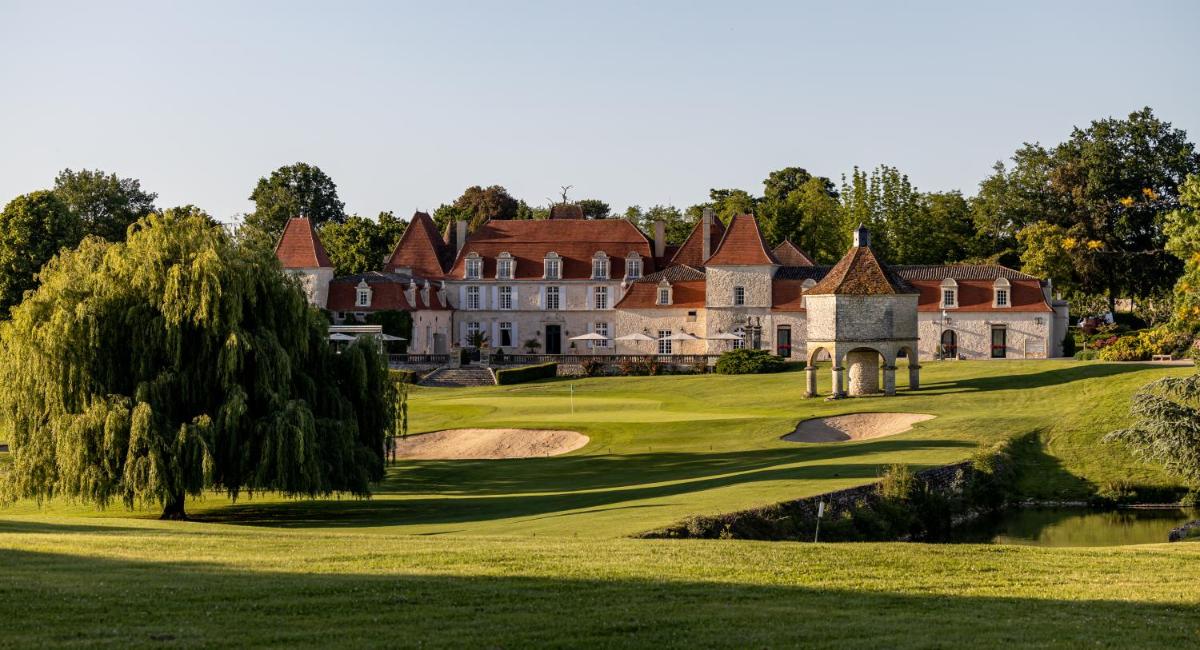 un vieux manoir sur un terrain de golf avec un étang dans l'établissement Château des Vigiers, à Monestier