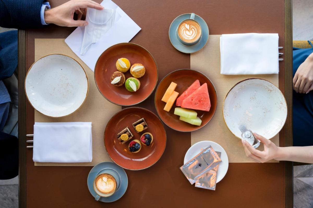 a table with plates of food on it at Hyatt Centric Janakpuri New Delhi in New Delhi