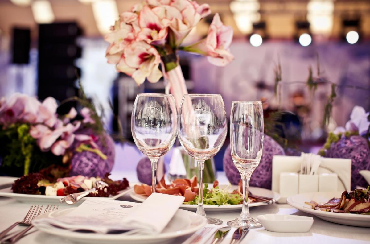 a table with wine glasses and plates of food at Hyatt Centric Janakpuri New Delhi in New Delhi