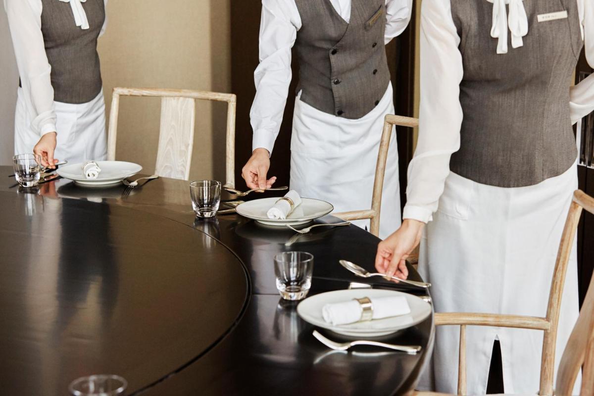 two women standing around a table with plates on it at Hyatt Centric Janakpuri New Delhi in New Delhi