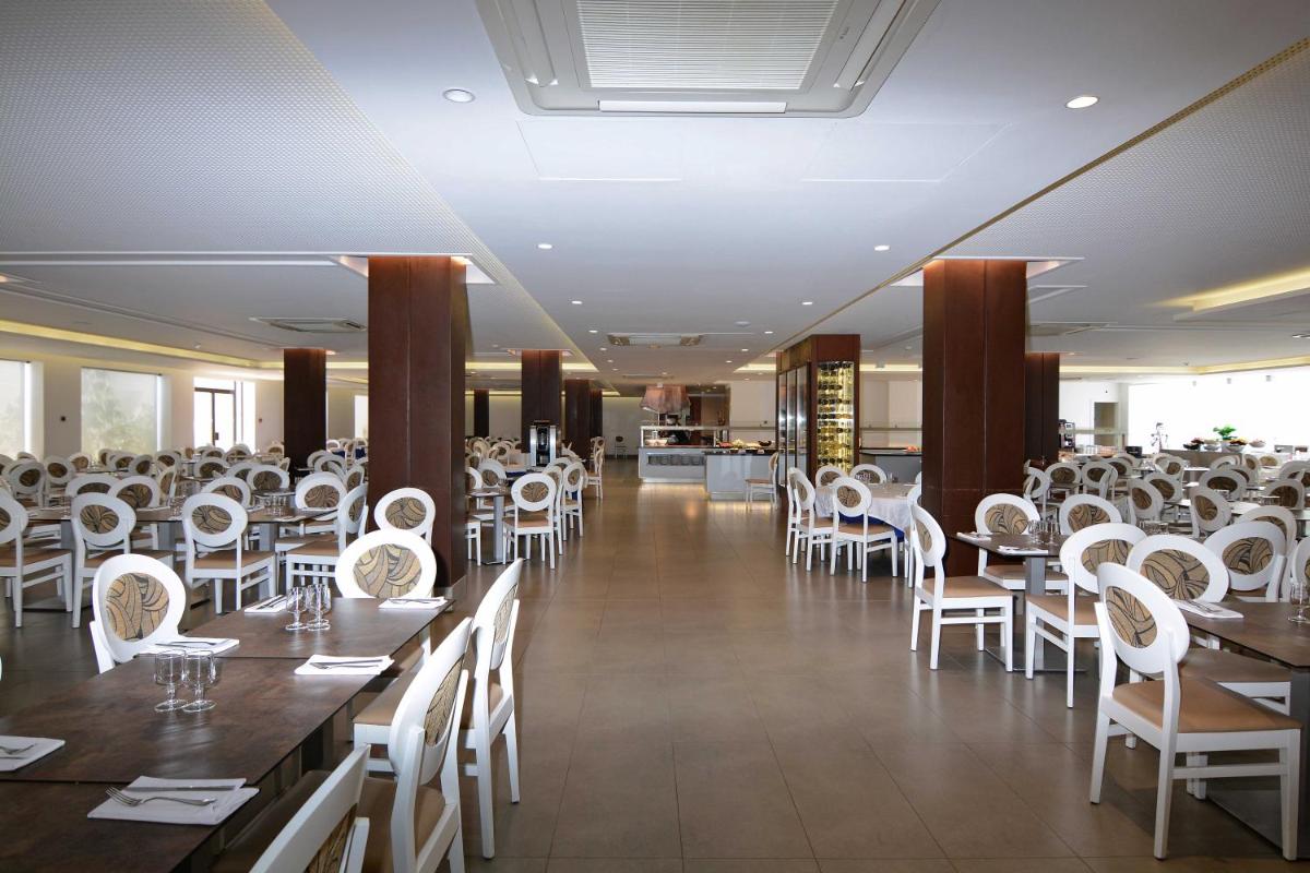 Un comedor con mesas y sillas blancas. en Don Angel & SPA & Padel- Adults Recommended, en Santa Susanna