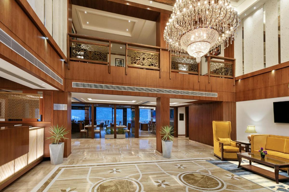 a lobby of a hotel with a chandelier at The Orchid Manali - a Boutique Hotel in Manāli a lobby of a hotel with a chandelier at The Orchid Manali - a Boutique Hotel in Manāli