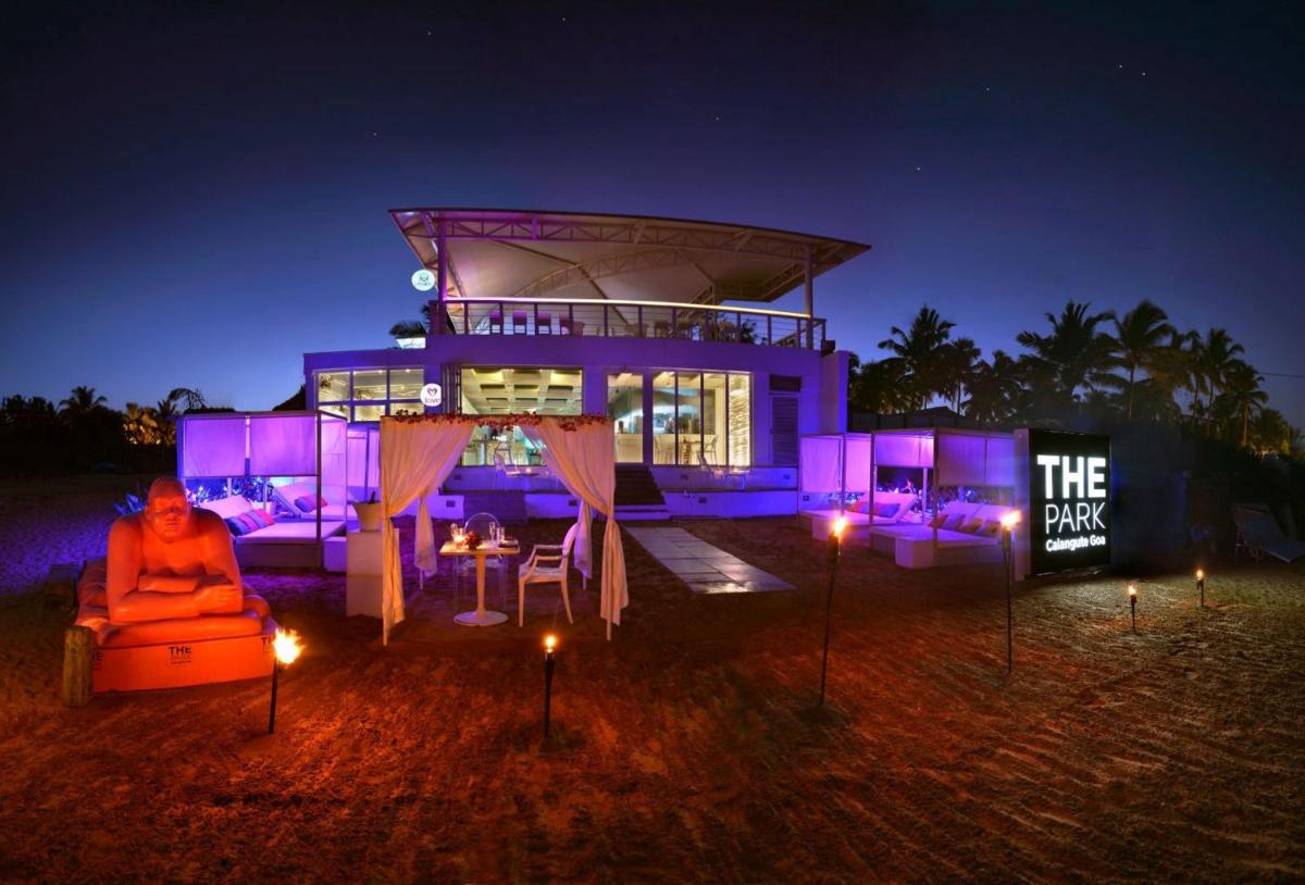 a man sitting in a chair in front of a house at night at The Park Calangute Goa in Calangute a man sitting in a chair in front of a house at night at The Park Calangute Goa in Calangute
