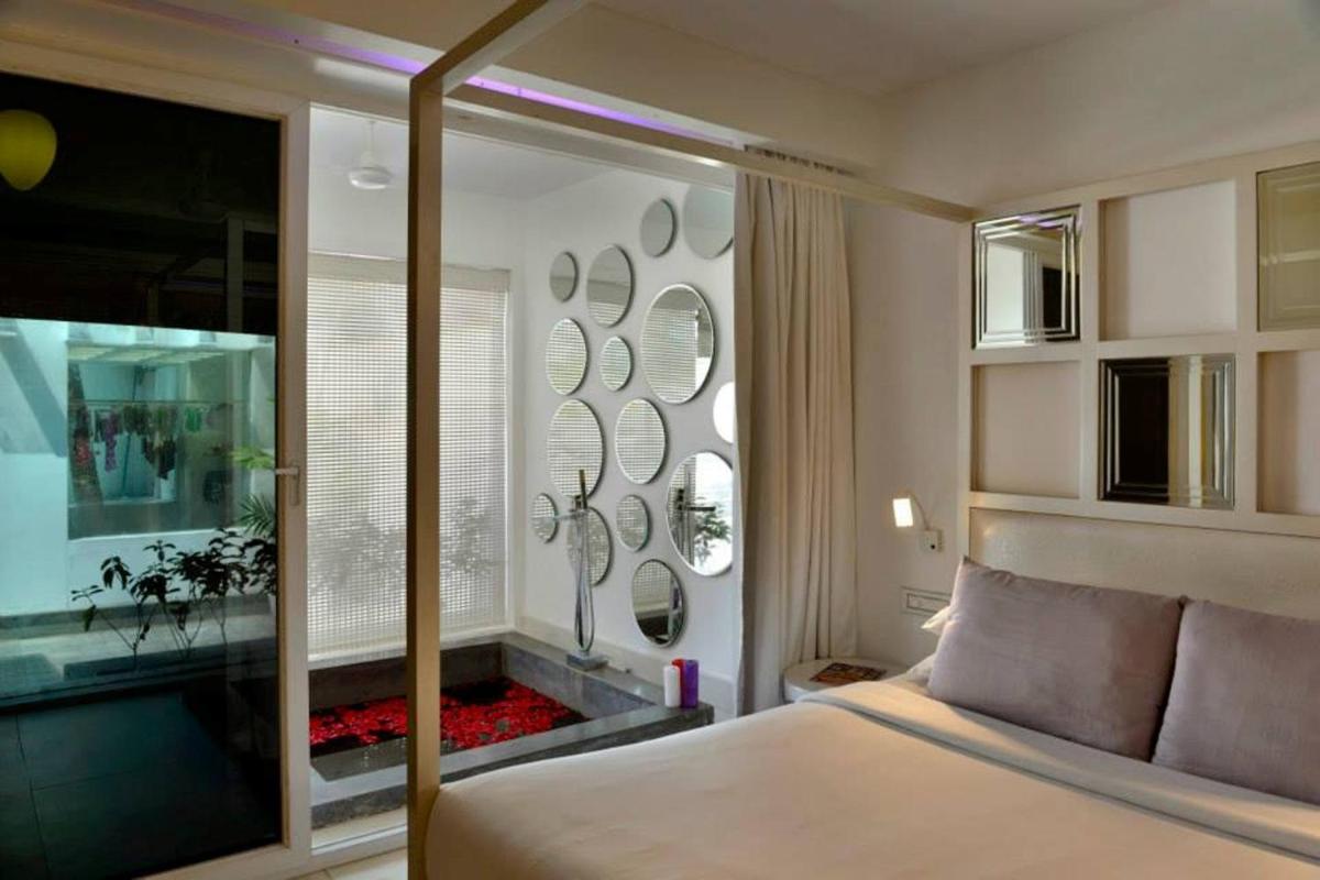 a bedroom with a bed and a window with a fish tank at The Park Calangute Goa in Calangute a bedroom with a bed and a window with a fish tank at The Park Calangute Goa in Calangute