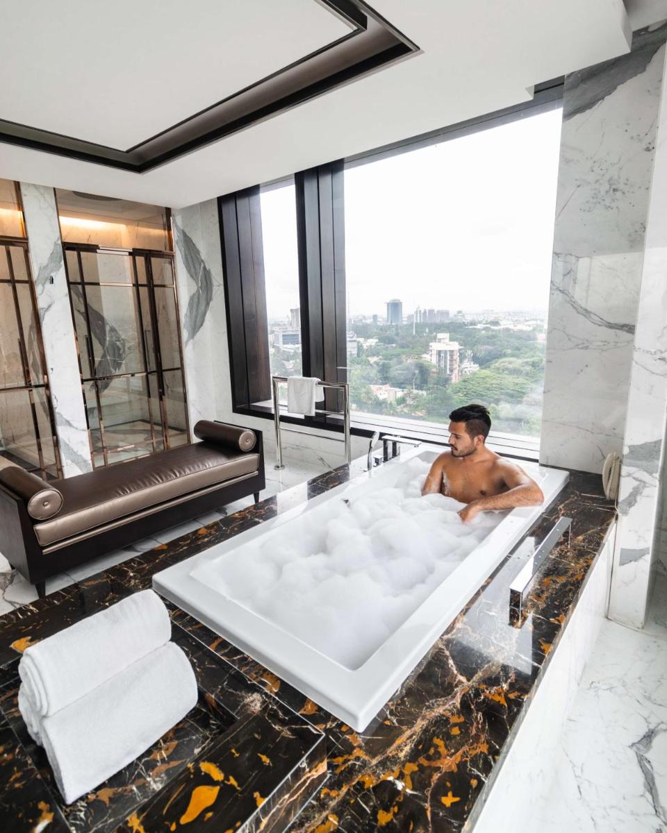 a man sitting in a bath tub in a hotel room at Shangri-La Bengaluru in Bengaluru a man sitting in a bath tub in a hotel room at Shangri-La Bengaluru in Bengaluru