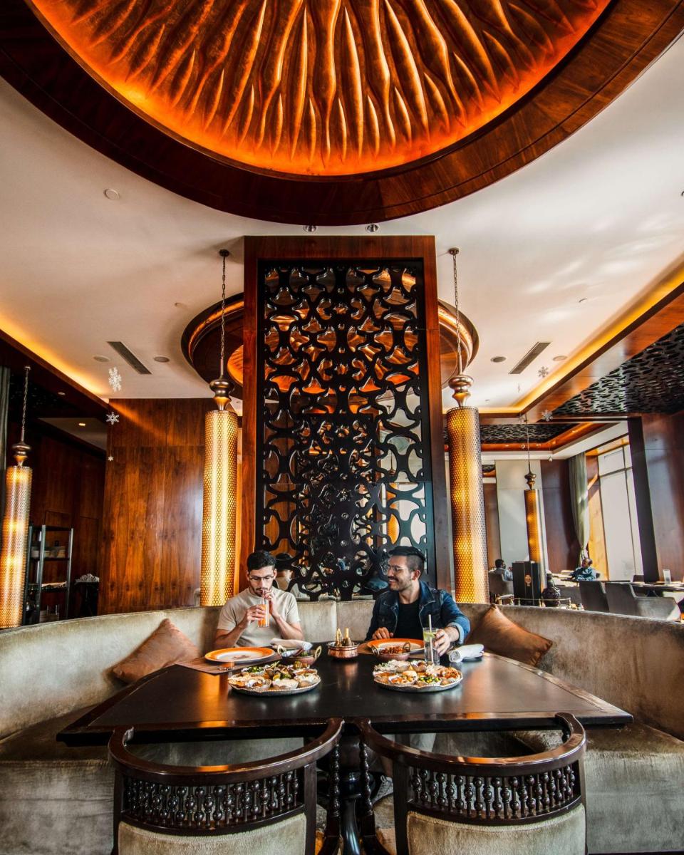 two people sitting at a table in a restaurant at Shangri-La Bengaluru in Bengaluru two people sitting at a table in a restaurant at Shangri-La Bengaluru in Bengaluru
