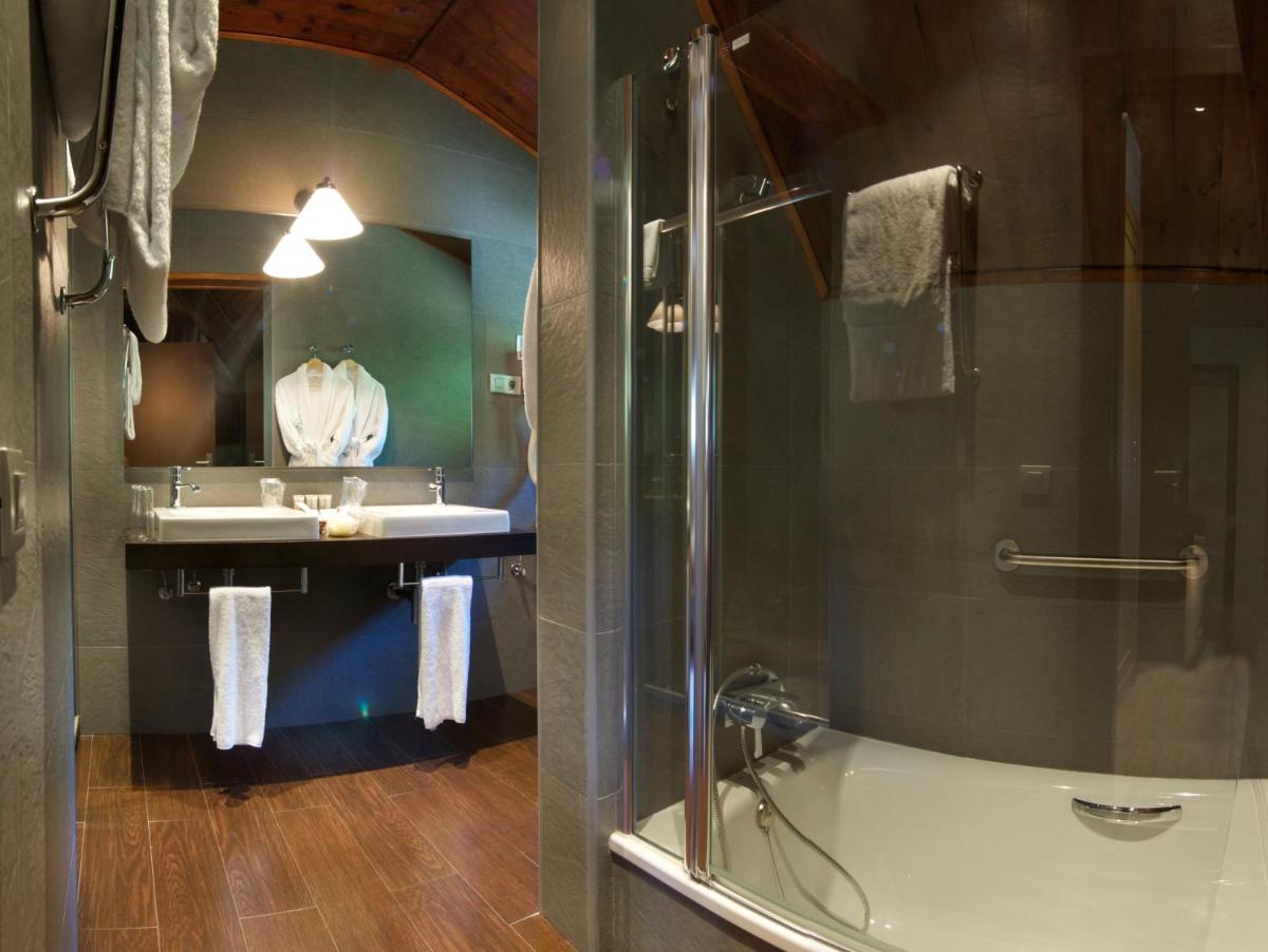 un baño con ducha y lavabo en Hotel Manantial, en Caldes de Boí