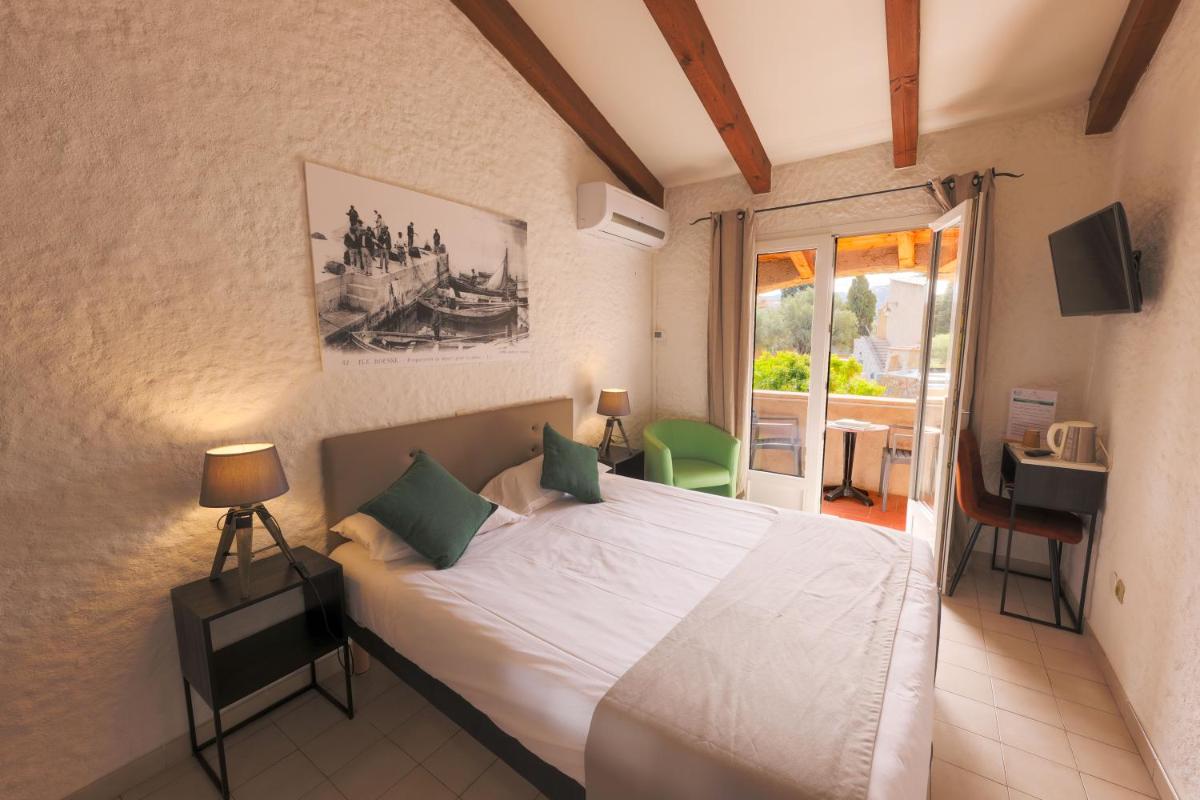 une chambre avec un grand lit et un balcon dans l'établissement Hôtel Casa Rossa & Spa, à LʼÎle-Rousse