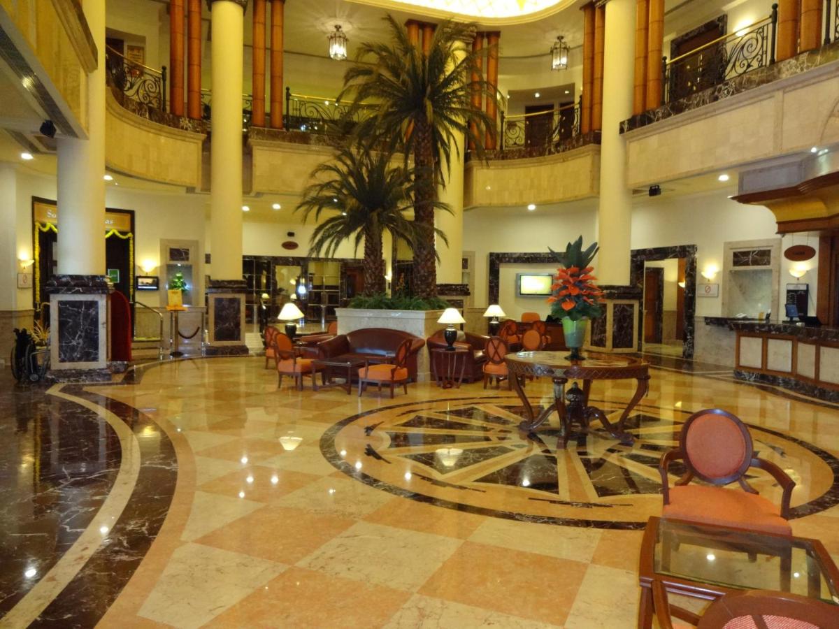 a lobby with chairs and tables in a building at The Residency Towers in Chennai