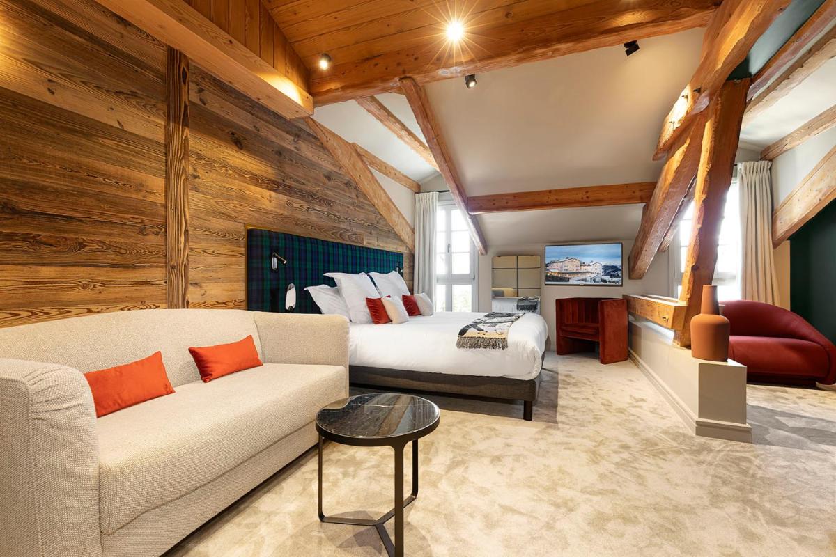 - un salon avec un canapé et un lit dans une chambre dans l'établissement Hotel Le Chabichou, à Courchevel