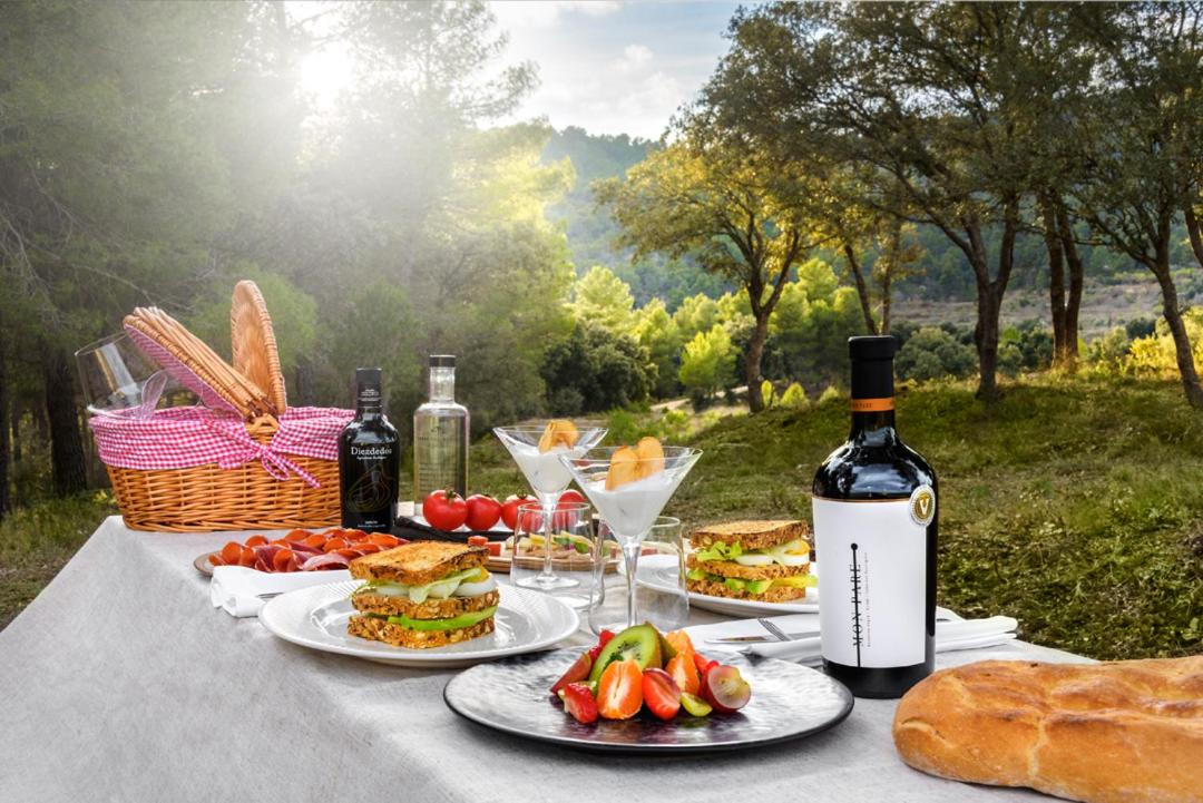 una mesa con platos de comida y botellas de vino en Torre del Marqués Hotel Spa & Winery - Small Luxury Hotels, en Monroyo