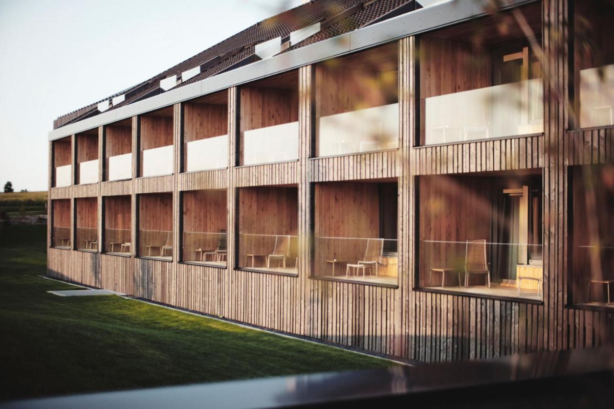 ein Gebäude mit Fenstern und Stühlen auf einem Feld in der Unterkunft Der Öschberghof - Die 101 besten Hotels in Donaueschingen