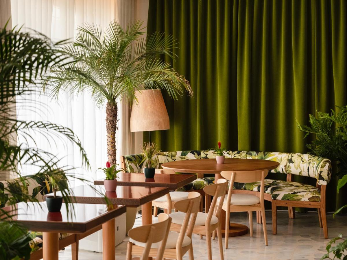 Un comedor con una mesa y una cortina verde. en The Standard, Ibiza, en Ibiza