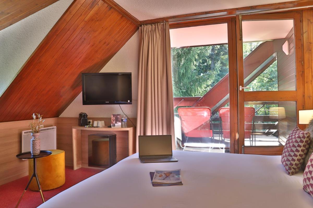 - une chambre avec un lit et une télévision dans l'établissement SOWELL HOTELS Mont Blanc et SPA, à Saint-Gervais-les-Bains