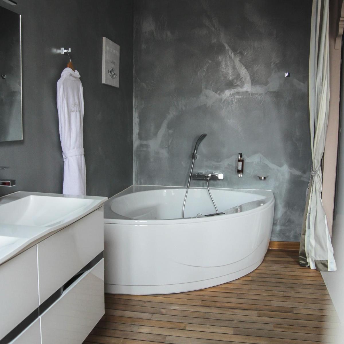 une salle de bain avec une baignoire blanche et un lavabo dans l'établissement Hôtel Le Petit Périer, à Laval