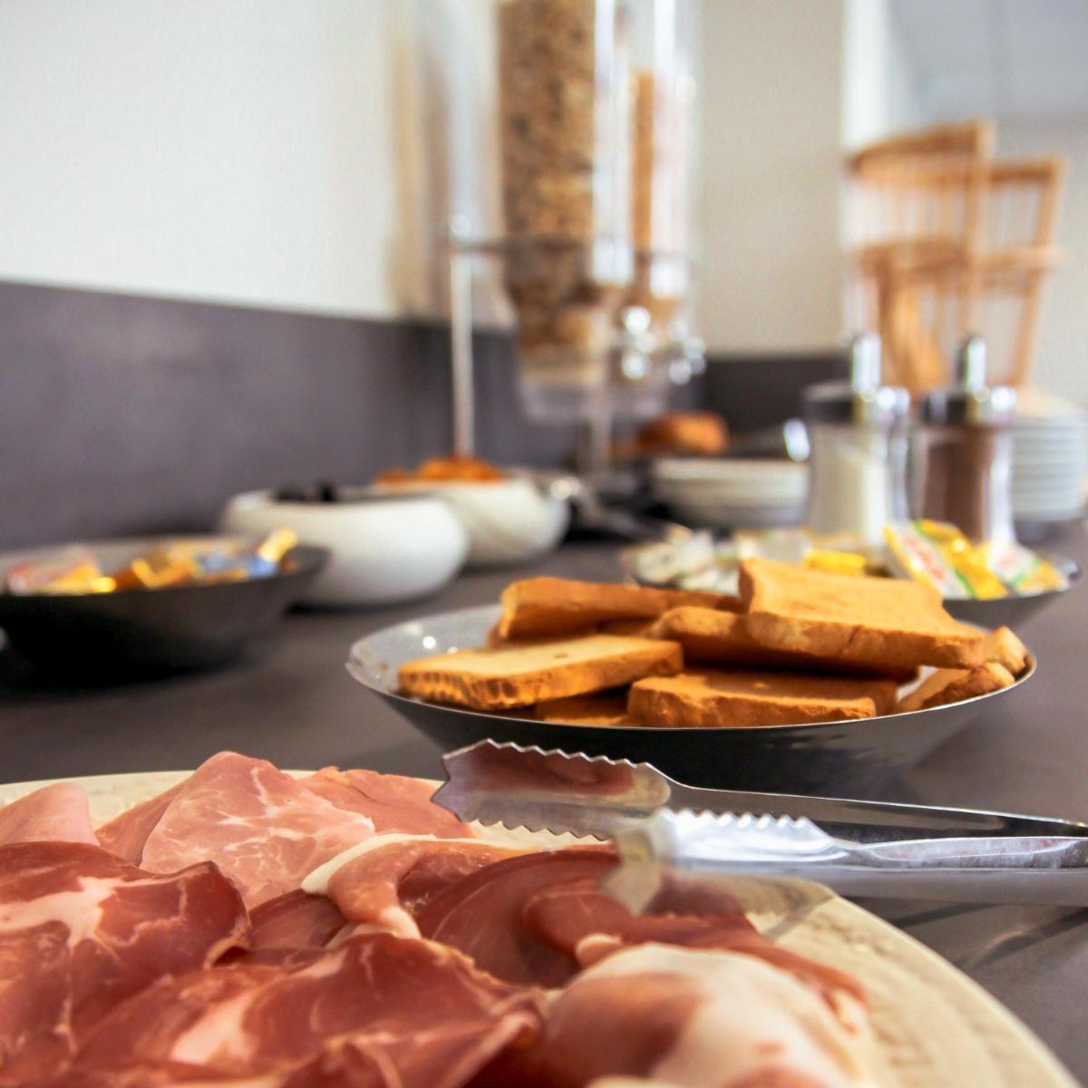 une table avec des assiettes de nourriture sur une table dans l'établissement Hôtel Le Petit Périer, à Laval 22 autres photos