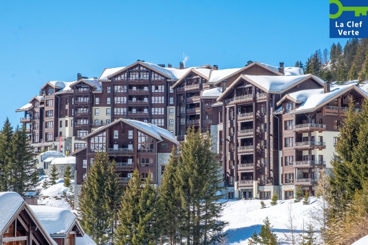 un immeuble avec de la neige sur les toits dans l'établissement Résidence Pierre & Vacances Premium Les Terrasses d'Hélios, à Flaine