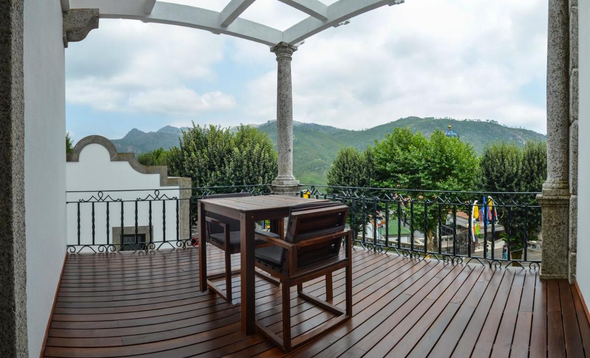 um deque de madeira com uma mesa numa varanda em Hotel São Bento da Porta Aberta & Spa no Gerês