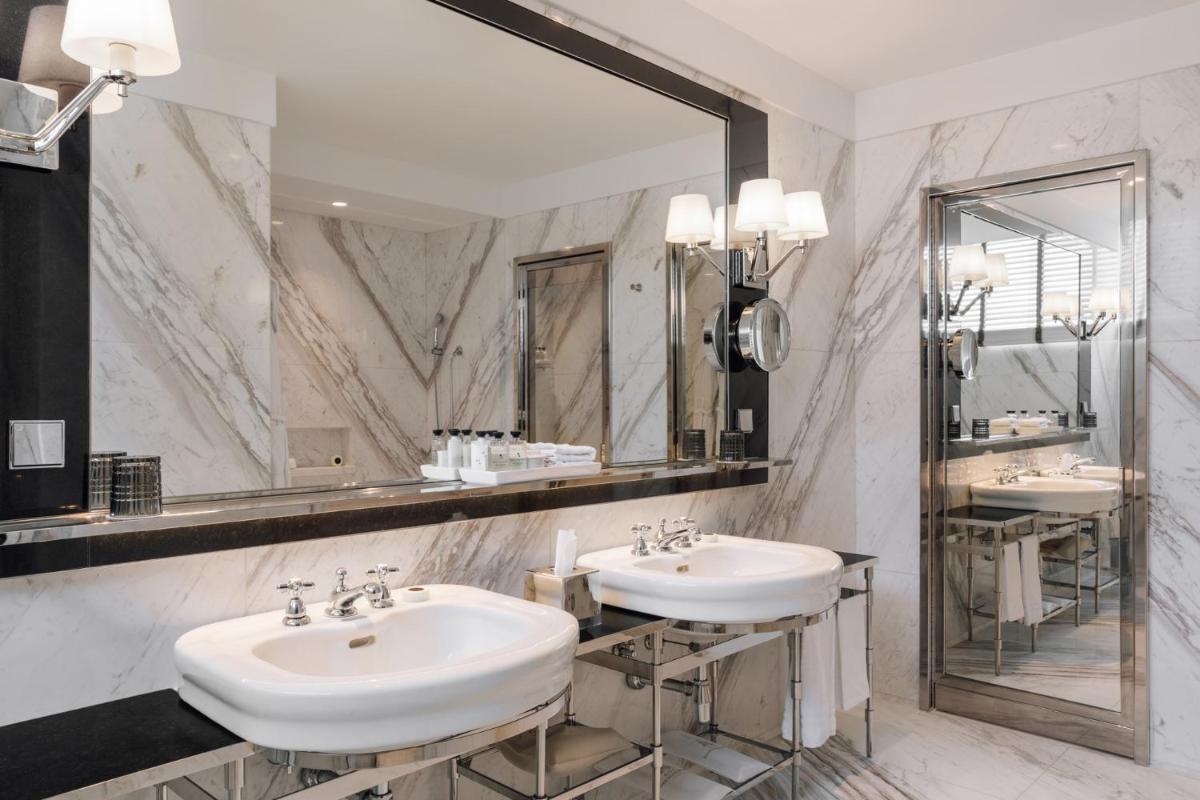 um banheiro com duas pias e um espelho grande em Four Seasons Hotel Ritz Lisbon em Lisboa