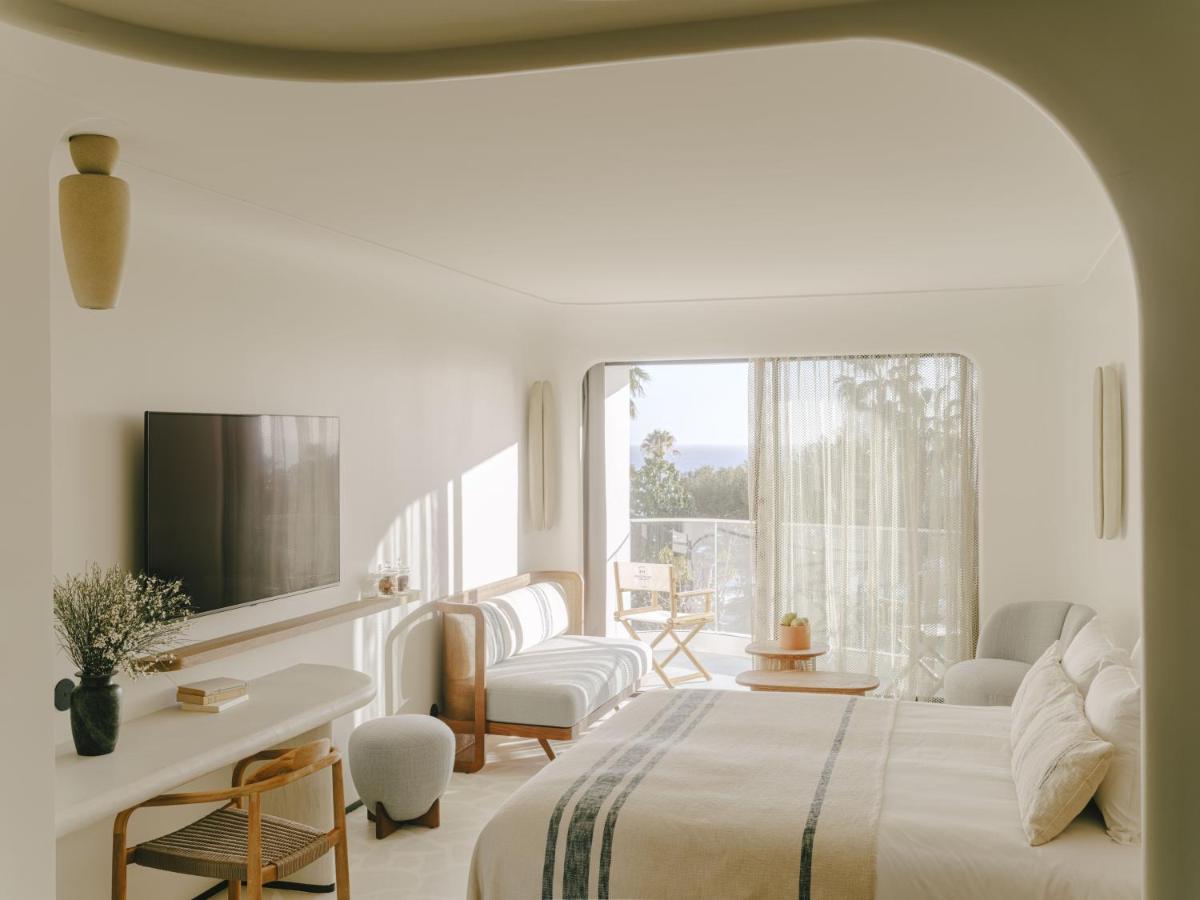 une chambre blanche avec un lit et une fenêtre dans l'établissement Hôtel & Spa Belle Plage, à Cannes