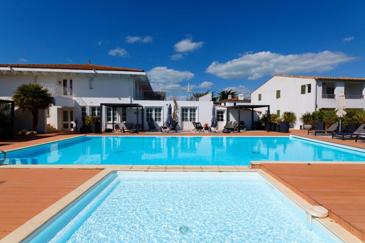 une piscine devant une villa dans l'établissement HR Hôtel-Restaurant & Spa Marin, à La Flotte une piscine devant une villa dans l'établissement HR Hôtel-Restaurant & Spa Marin, à La Flotte