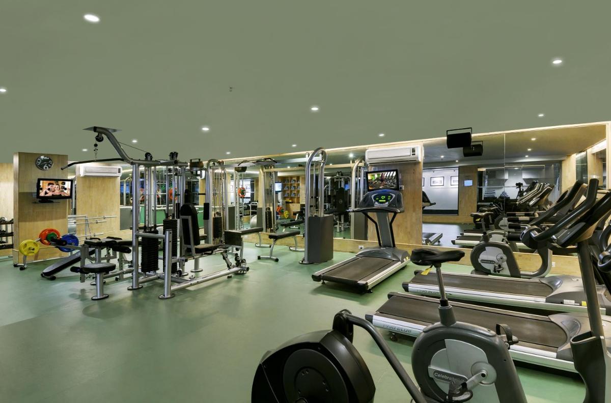 a gym with several treadmills and cardio machines at Grand Mercure Bangalore - An Accor Brand in Bengaluru