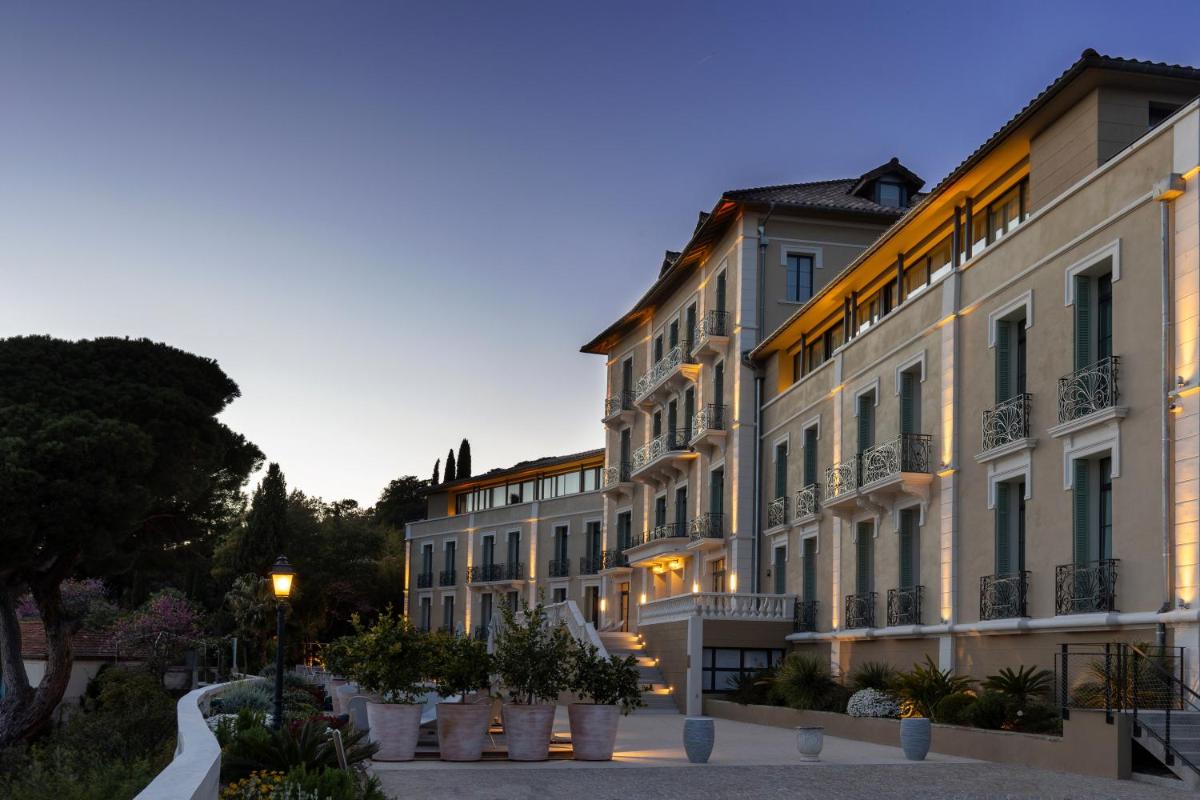 une rangée de bâtiments dans une rue au crépuscule dans l'établissement Eden Rose Grand Hotel BW Premier Collection, à Bormes-les-Mimosas