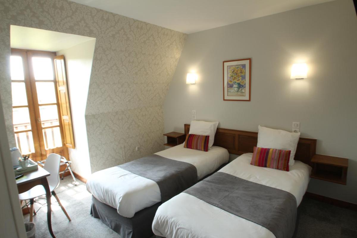 Un ou plusieurs lits dans un hébergement de l'établissement Logis Hotel Archambeau