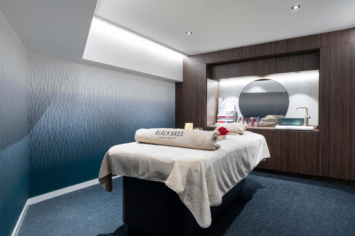 une chambre avec un lit et un miroir dans l'établissement Black Bass Hotel, à Sévrier