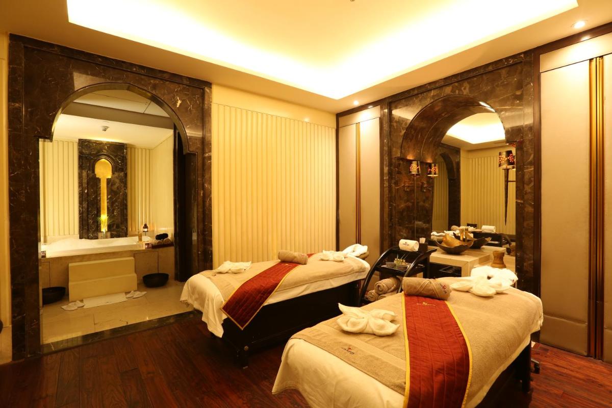 a hotel room with two beds and a bathroom at Crowne Plaza New Delhi Mayur Vihar Noida by IHG in New Delhi