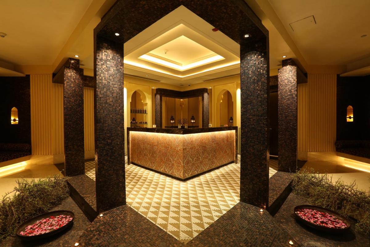 a lobby with a bar in the center of a building at Crowne Plaza New Delhi Mayur Vihar Noida by IHG in New Delhi