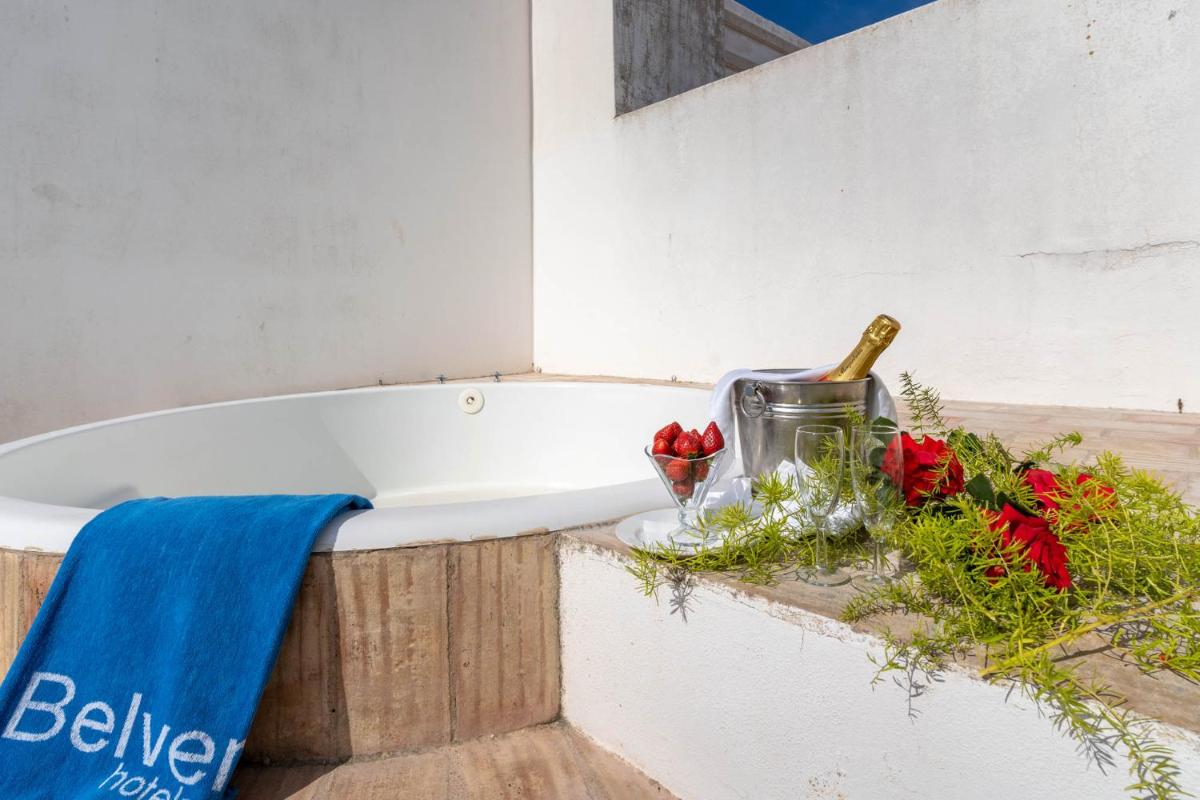 uma banheira com flores e uma garrafa de champanhe em Boa Vista Hotel & Spa - Adults Only em Albufeira
