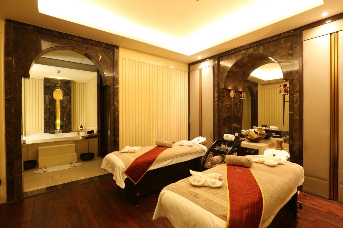 a hotel room with two beds and a bathroom at Crowne Plaza New Delhi Mayur Vihar Noida by IHG in New Delhi
