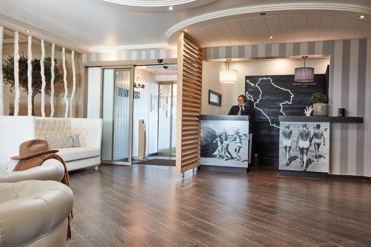 un homme debout à un comptoir dans un hall dans l'établissement Hôtel Atalante - Relais Thalasso & Spa, à Sainte-Marie de Ré 110 autres photos