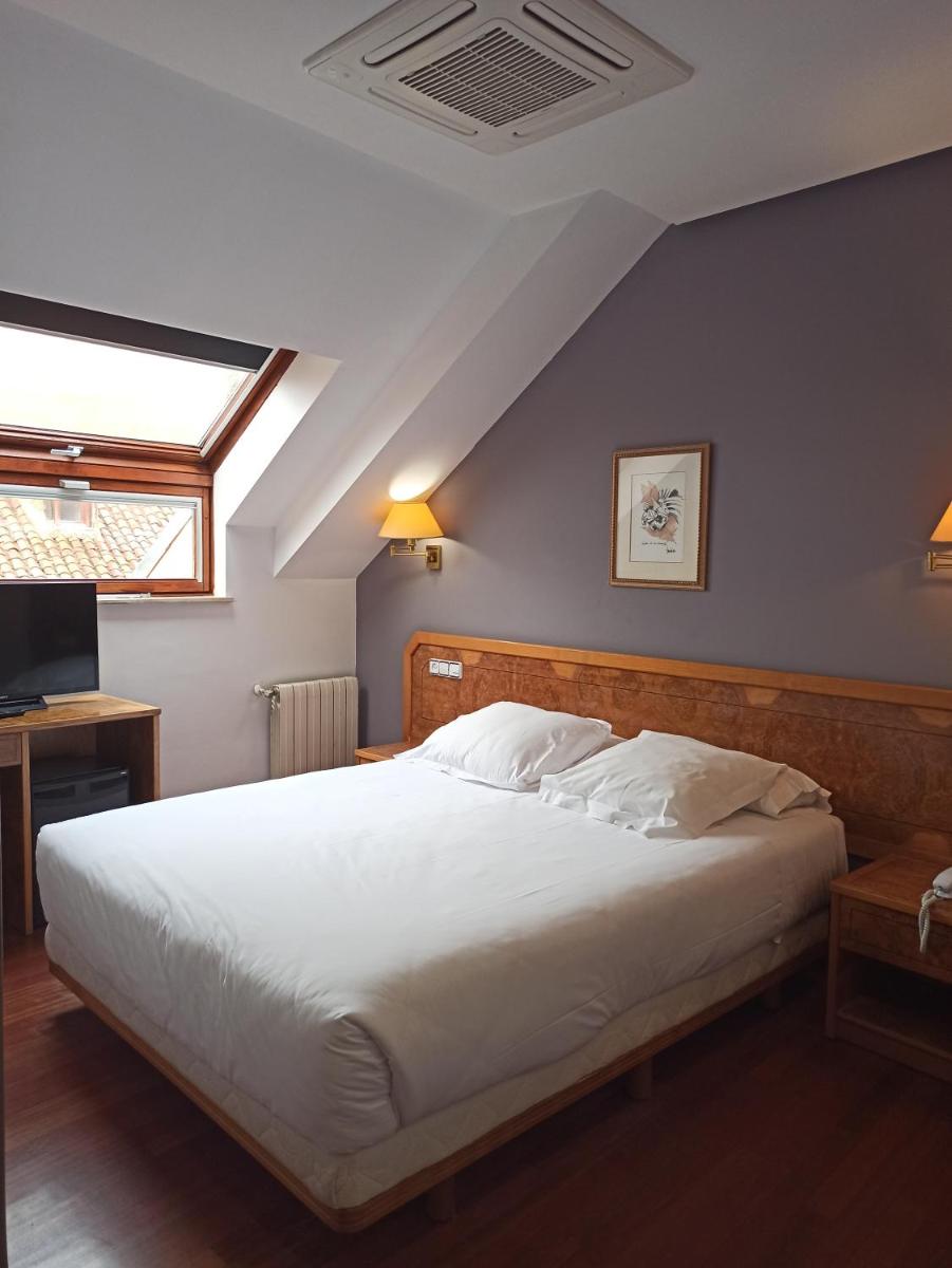 1 dormitorio con cama blanca grande y techo en ARVA Spa París, en León
