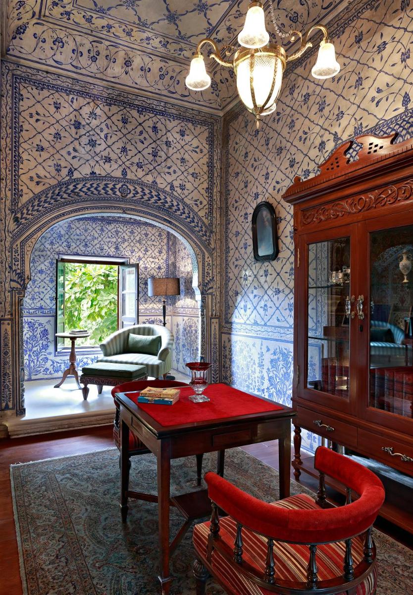 a living room with a table and a couch at Samode Haveli in Jaipur