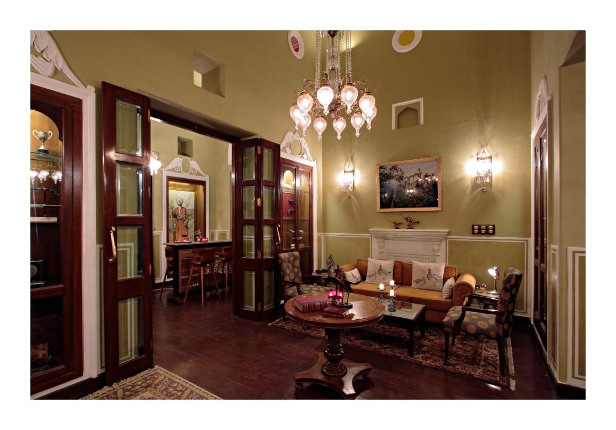 a living room with a couch and a table at Samode Haveli in Jaipur