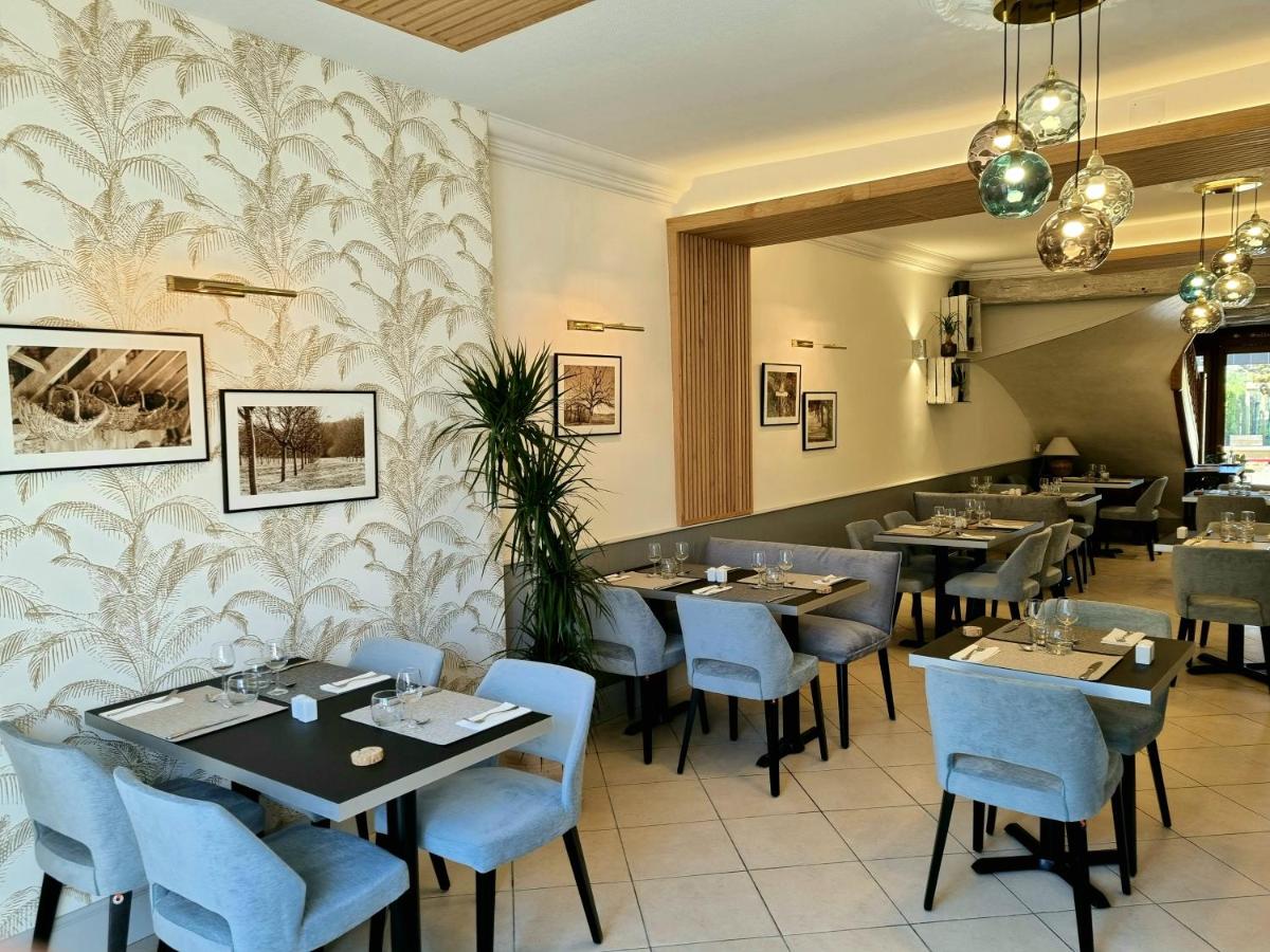 une salle à manger avec des tables et des chaises bleues dans l'établissement Logis Hotel Archambeau, à Thonac