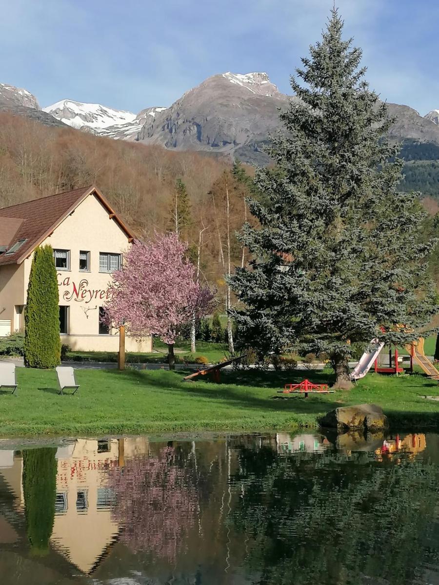 un arbre en face d'une maison et d'un lac dans l'établissement La Neyrette, à Saint-Disdier