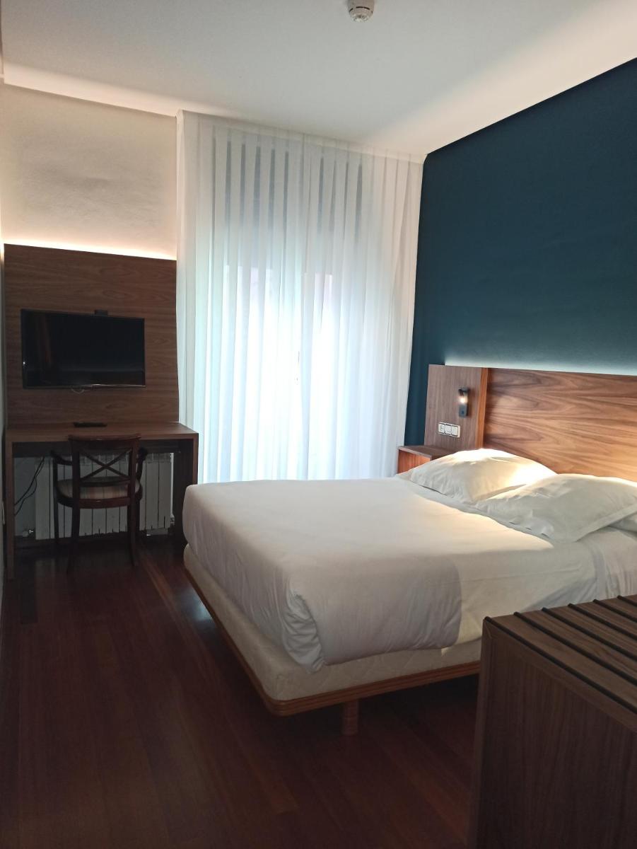 Un dormitorio con una cama, un escritorio y un televisor. en ARVA Spa París, en León 144 fotos más