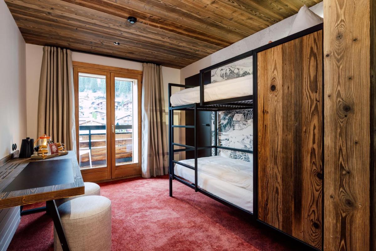 Cette chambre dispose de lits superposés, d'un bureau et d'une fenêtre. dans l'établissement Hôtel Névé, à Morzine 89 autres photos