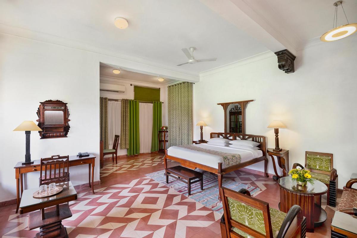 a bedroom with a bed and a table and chairs at Neemrana Fort-Palace in Neemrana