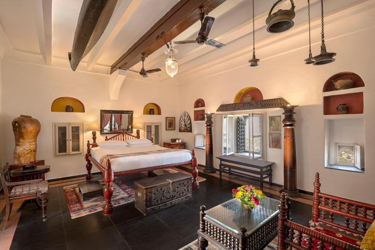 a bedroom with a bed and a table in a room at Neemrana Fort-Palace in Neemrana